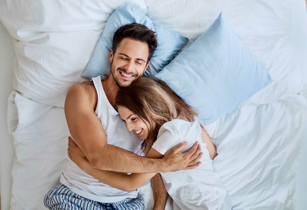 couple laying together on a bed